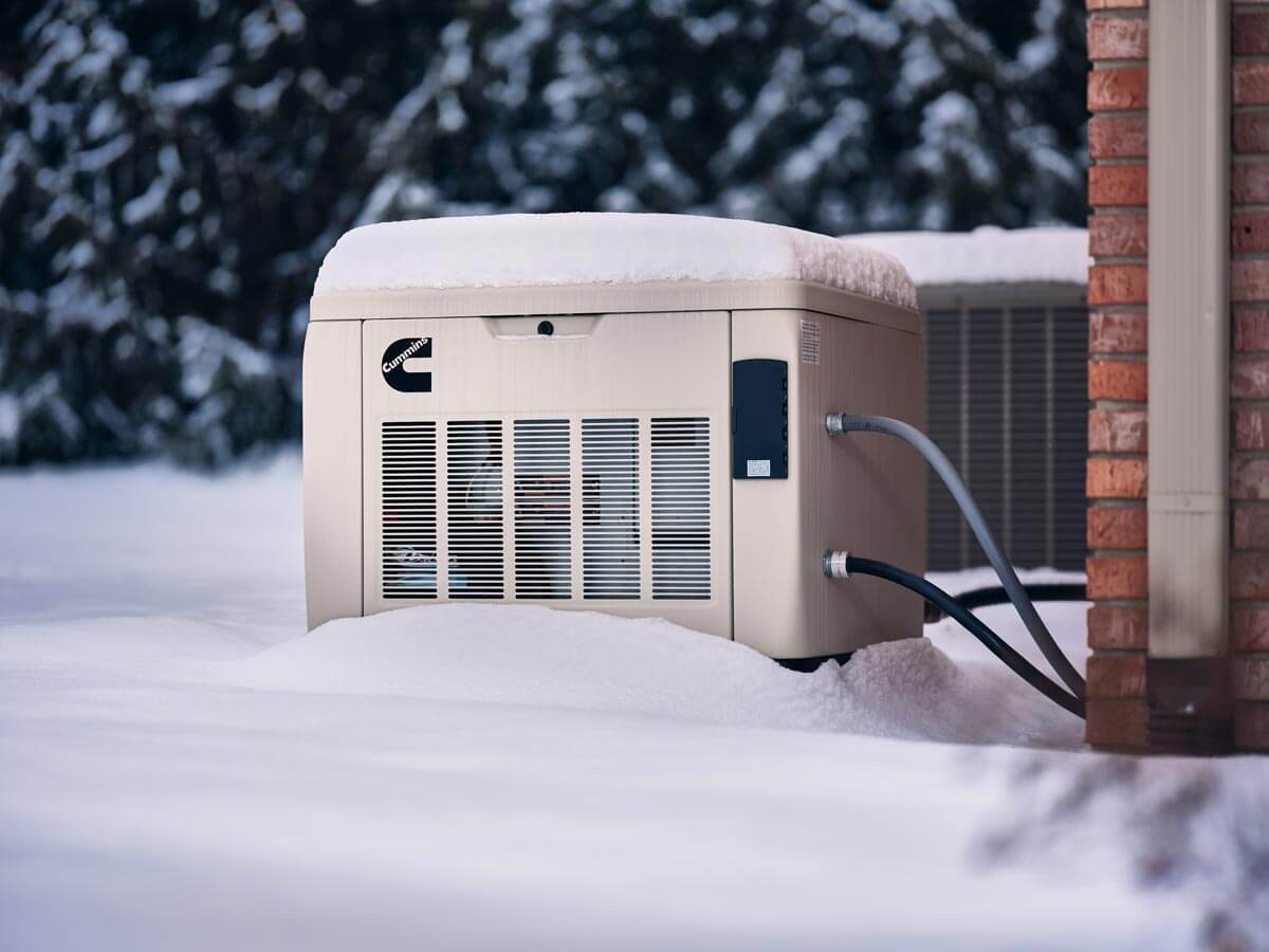 Cummins standby generator in the snow outside a brick building
